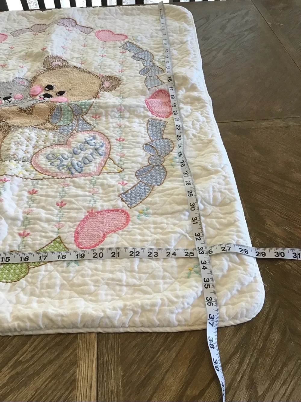 Vintage handmade baby quilt featuring embroidered teddy bears